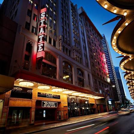 QT Sydney — the heritage State Theatre building lit at night with its iconic red STATE neon sign.
